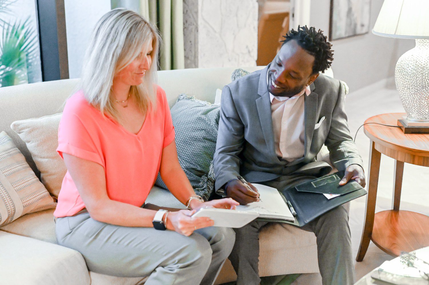 Man and woman discussing documents on sofa.